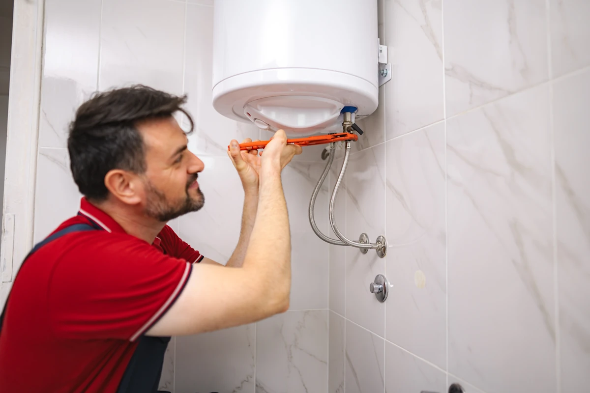 Un homme qui fait le détartrage chauffe eau électrique