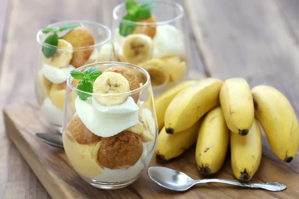 Des bananes à côté des verres de dessert avec des tranches de banane