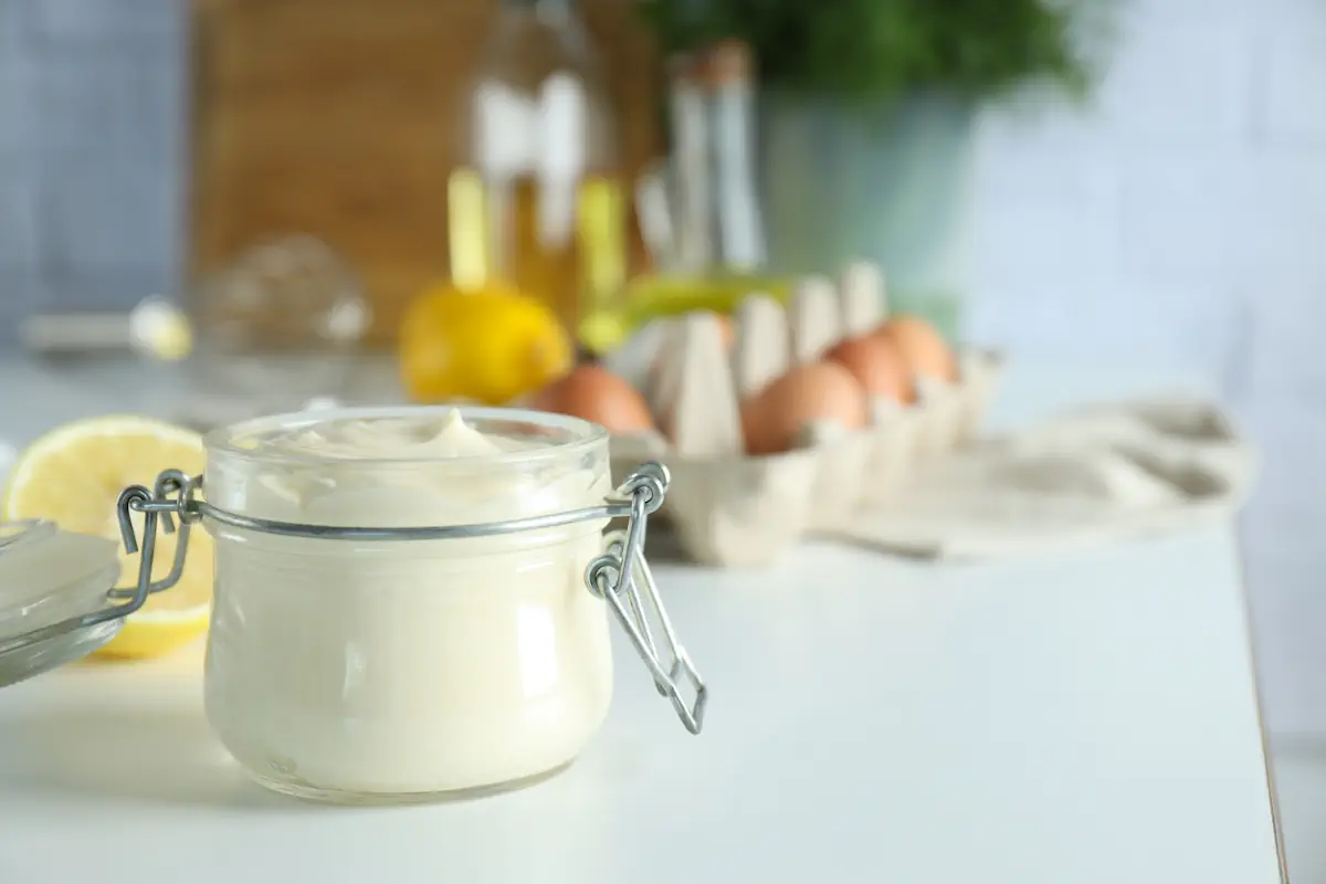 Un pot de mayonnaise posé sur une surface blanche