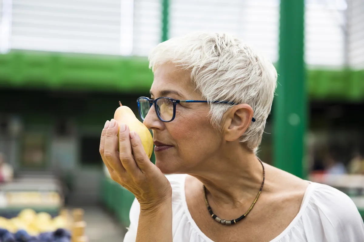 Une femme qui sent une poire